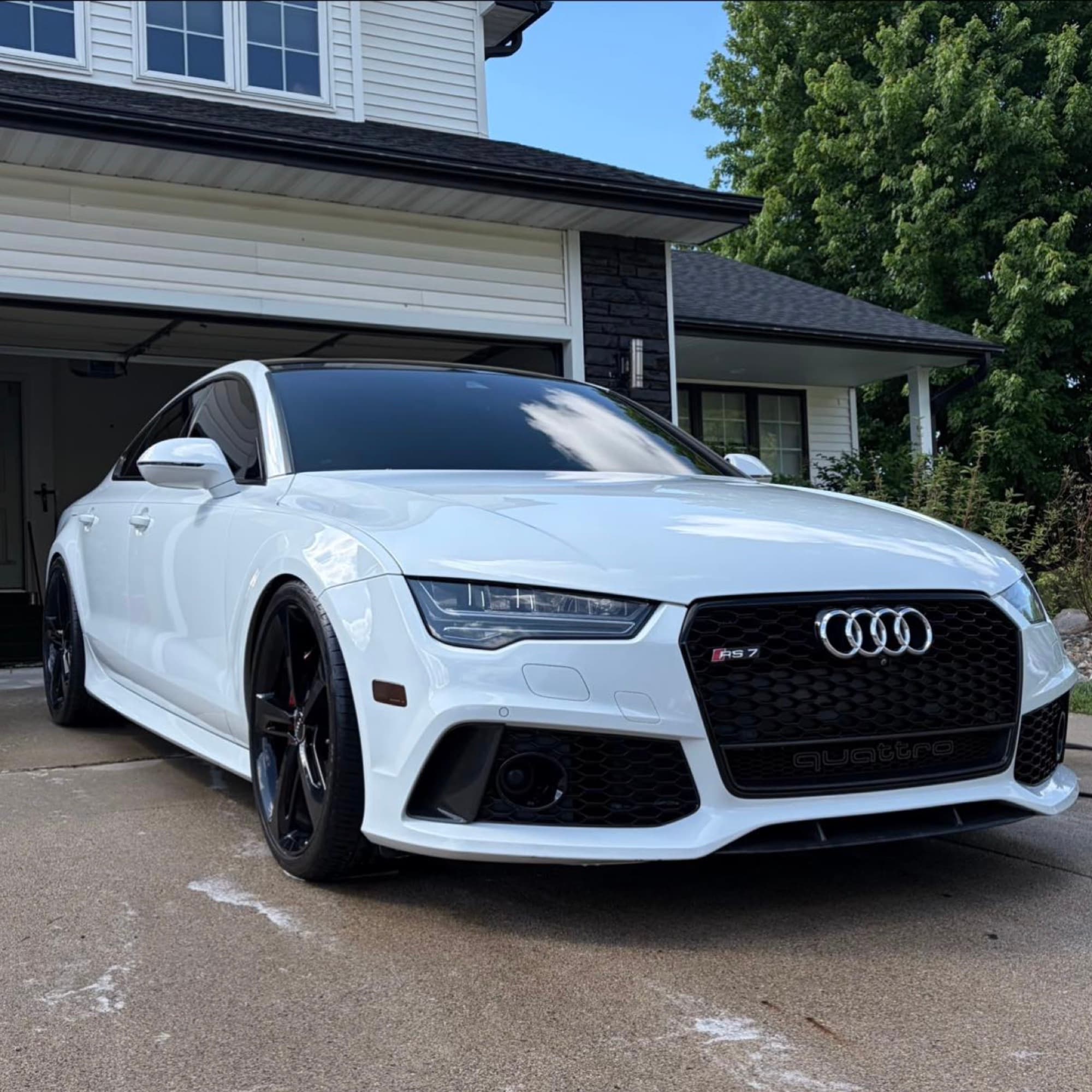 White Audi RS7 freshly hand-washed in a residential driveway in Overland Park